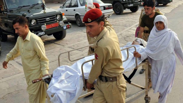 Pakistani soldiers carry the injured Malala Yousafzai.