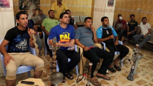 Iraqi youths watch a soccer game in the World Cup at a cafe in the Shiite stronghold of Sadr City, Baghdad, Iraq.