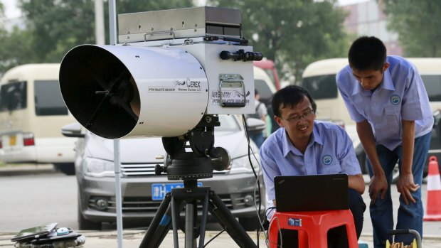 Engineers of Tianjin environmental monitoring centre use a device to check the level of hydrogen cyanide present in the air at a monitoring station within a three-kilometre exclusion zone around last week's explosion site.