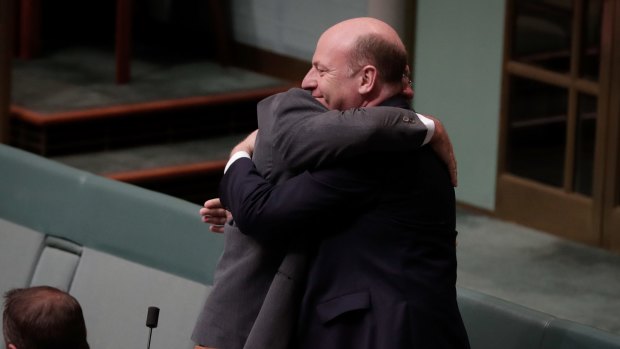 Warren Entsch embraces Liberal MP Trent Zimmerman after he spoke during debate on the Marriage Amendment Bill in the House of Representatives at Parliament House in Canberra on Monday 4 December 2017. fedpol Photo: Alex Ellinghausen