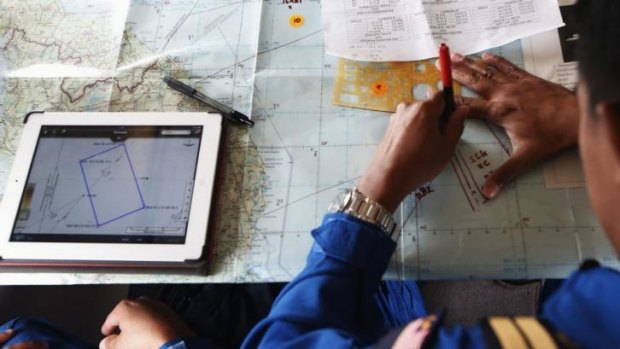 A Malaysian Maritime Enforcement Agency pilot studies a map onboard a Japanese aircraft.