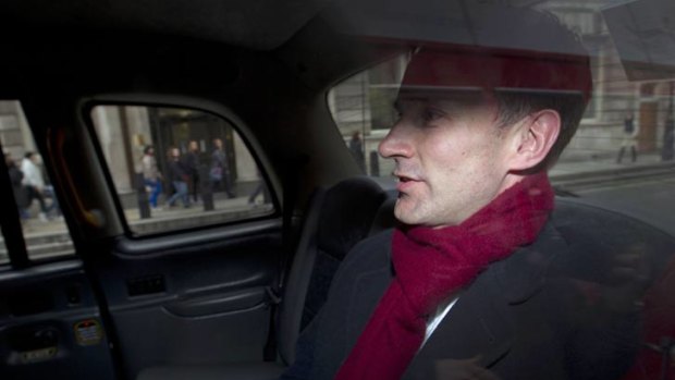 Under pressure ... British Culture Secretary Jeremy Hunt leaves his office in a taxi in central London.