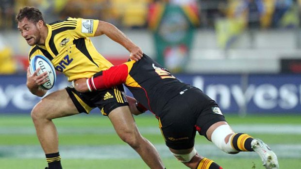 Jack Lam of the Hurricanes is tackled by Isaac Ross of the Chiefs.
