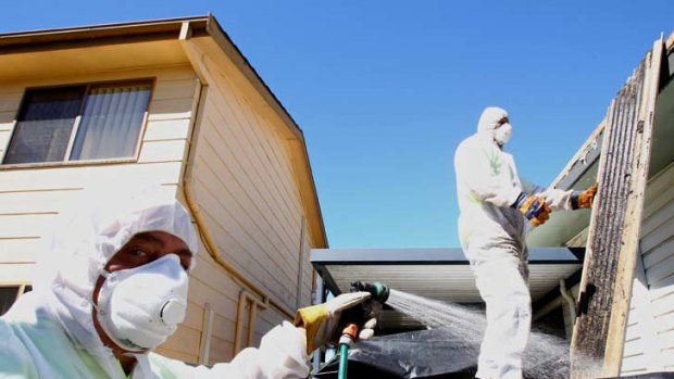 Paying for the experts &#8230; John Limpus and one of his team remove asbestos on the central coast.