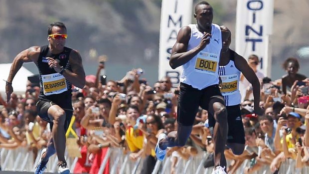 Jamaican Olympic gold medallist Usain Bolt (C) leaps ahead of Brazil's Bruno de Barros (L) and Ecuador's Alex Quinonez to win the "Mano a Mano Men's 150 metres" challenge on Copacabana beach.