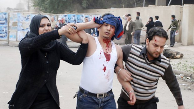 Residents of Baghdad help a bleeding man who was wounded in a bomb attack.