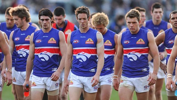Sick puppies: The Western Bulldogs sulk from Skilled Stadium after their 61-point loss to Geelong yesterday.