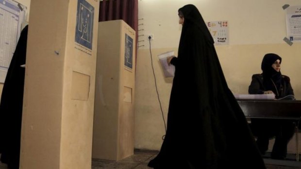 An Iraqi prepares to cast her vote at a polling station in Baghdad.