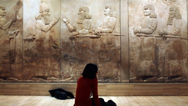 Step back in time: A visitor sits in front of ancient Assyrian stone reliefs at the reopened National Museum in Baghdad.