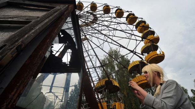 A tourist from Sweden takes a picture in the abandoned amusement park of the ghost city of Pripyat, near the Chernobyl nuclear power plant.