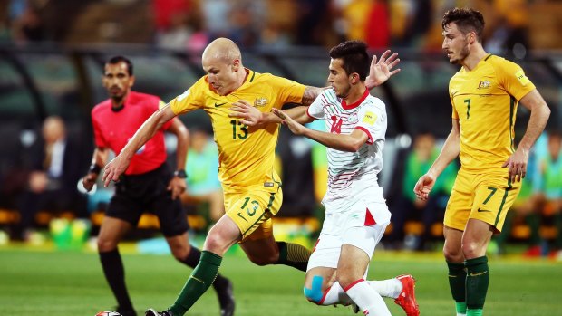 Out of my way: Aaron Mooy bustles through the midfield during the World Cup qualifier against Tajikistan in Adelaide on Thursday night.