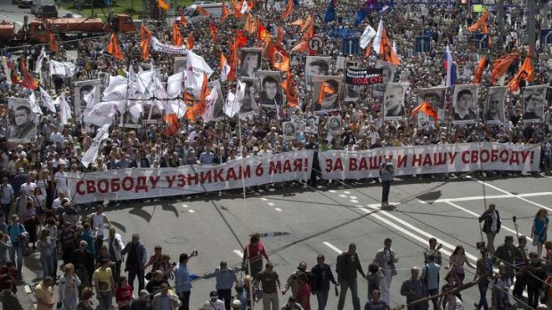 Russian opposition protesters some holding portraits of political prisoners  shout anti-Putin slogans as they march through a street next to the Kremlin in Moscow on Wednesday, June 12, 2013. The banner reads liberty to the captives on May 6! for our and your freedom!