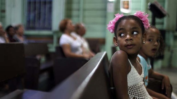 Waiting game ... young worshippers in a dilapidated church in Cuba's Santiago de Cuba, where the Pope will say Mass.