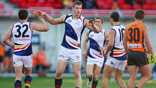 Josh Jenkins of the Crows shares the joy with his teammates after kicking a goal.