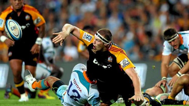 Brodie Retallick of the Chiefs offloads the ball in the tackle.