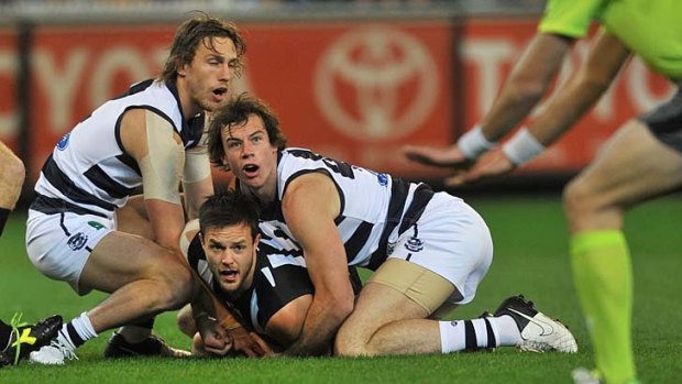 Caught: Collingwood's Nathan Brown is wrapped up by Geelong players at the soaked MCG yesterday.