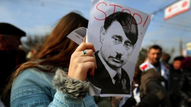 A protester with a caricature of Russian President Vladimir Putin at a pro-Ukrainian rally in the Crimean city of Simferopol.