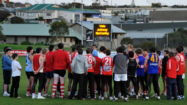 Players gather to remember John McCarthy at a Sorrento Football Club training session. Coach Troy Schwarze says an upcoming grand final has barely been mentioned in the wake of McCarthy’s death.