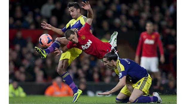 Manchester United's Javier Hernandez (centre) is brought down by Swansea City's Chico (bottom right) as Neil Taylor (left) also challenges for the ball.