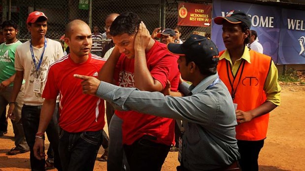 A fan of the Royal Challengers Bangalore is escorted to an ambulance after a suspected low-intensity bomb exploded outside the Chinnaswamy Stadium before an IPL game against the Mumbai Indians in April 2010.