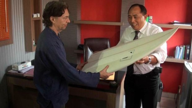 Brother John Maynard collects his missing brother's surfboard from Indonesian police.