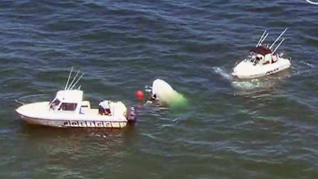 Aerial footage shows the boat capsized in the water in Port Phillip Bay.