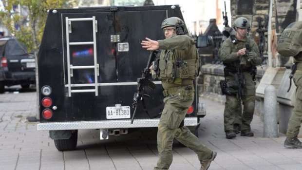 A Mounted Police intervention team clears the area at the entrance of Parliament in Ottawa following the attack.