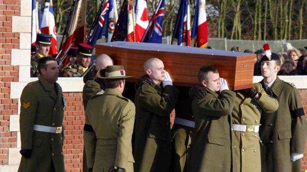 A bearer party carries the coffin of an Australian soldier during the service for the reburial of soldiers killed in the battle of Fromelles at Pheasant Wood military cemetery in  France.