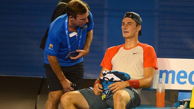 Bernard Tomic speaks to the doctor during his match against Rafael Nadal.