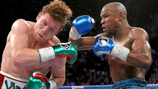 Telling blow: Mayweather (R) throws  throws a left at Saul Alvarez.