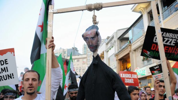 People displaying Turkish, Syrian and Palestinian flags, carry an effigy of Syrian leader Bashar Assad during a rally in Istanbul, Turkey.