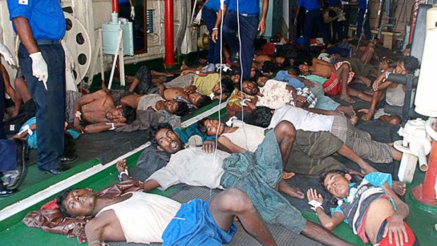 In recovery ... thirty-two Burmese asylum seekers rescued off Sri Lanka's eastern coast rest on the floor at a hospital in Galle.