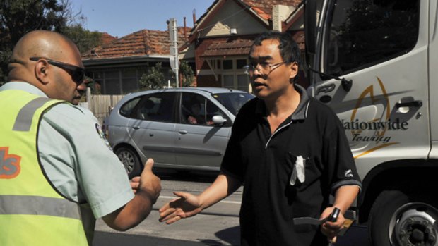 Zuo Chen confronts a VicRoads officer after finding that his car had been removed from High Street, Prahran.