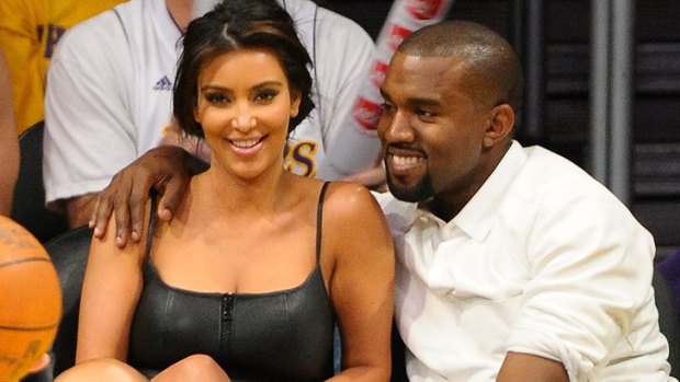 Famous curves ... Kim Kardashian and rumoured new beau, rapper Kanye West, get cosy at a basketball game.