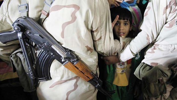 At the front line ... soldiers block a child who joined supporters of Colonel Gaddafi outside his compound in Tripoli, Bab al-Azizia.