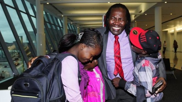 Felix Machiridza with his children from left, Christabel Tapiwa,14, Clarice Tanaka, 8, and  Clarence Takunda,13, arrived at Canberra International Airport after not seeing each other for four years.