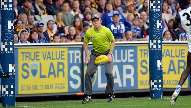 Goal umpire Michael Palm watches the ball bounce at the MCG.