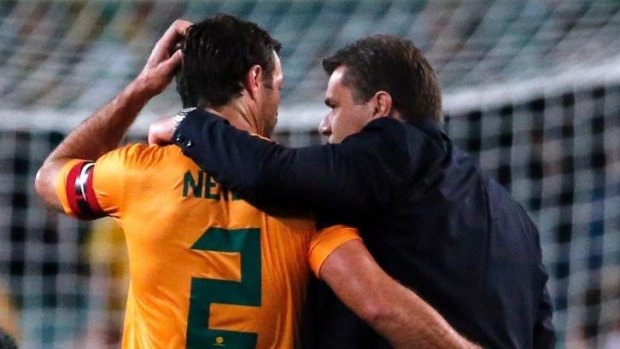 Australia's team coach Ange Postecoglou (R) hugs team captain Lucas Neill.