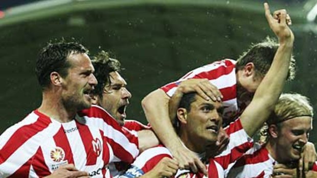 Melbourne Heart players celebrate their upset win over Melbourne Victory.