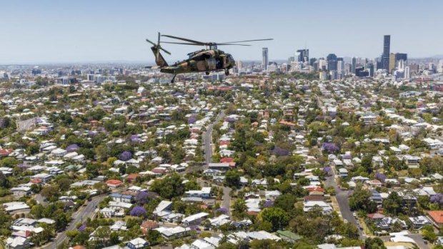 A Black Hawk helicopter flies over Brisbane.