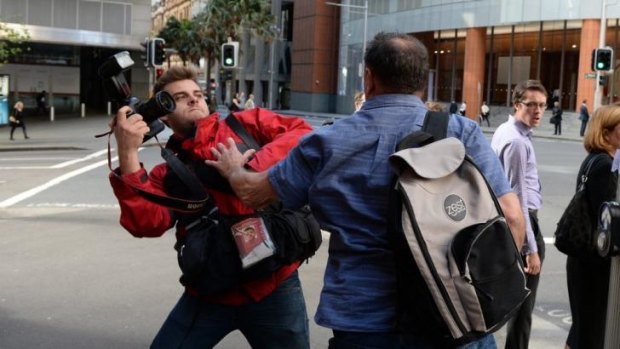 Former AWU official Bruce Wilson attacks a photographer outside the Royal Commission in Sydney.