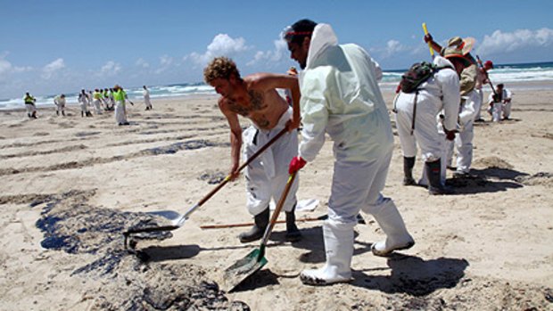 Workers start the mammoth clean-up shortly after the oil spill last March at Queensland's Tangalooma resort.