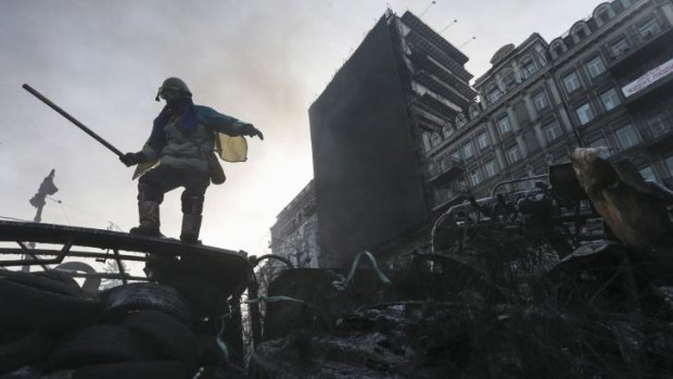 An anti-government protester stands on a barricade at the site of clashes with riot police in Kiev.