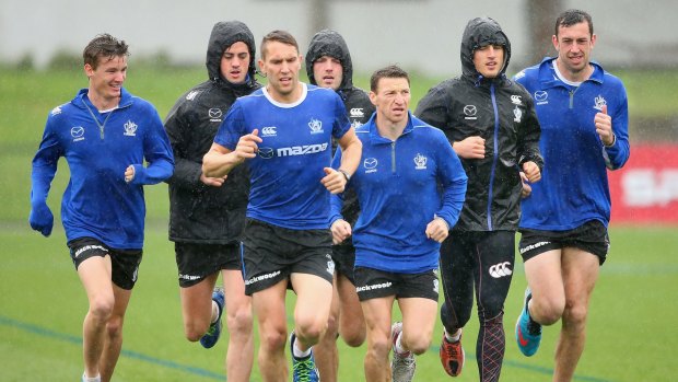 North Melbourne players go through their paces at a damp Arden Street on Monday.