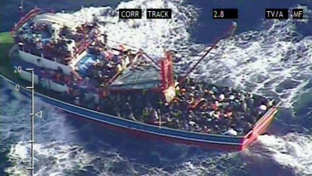 A large fishing trawler overloaded with refugees is pictured by the Cyprus Defence Ministry in heavy seas in the Mediterranean.