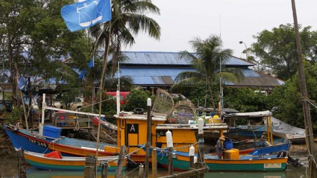 Fishing for votes: A flag of Malaysia's ruling National Front coalition flies as a man works on a fishing boat in Kuantan, Pahang state, Malaysia.