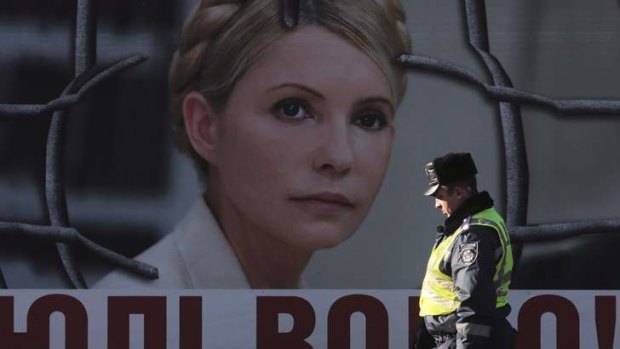 An Interior Ministry officer walks past a board displaying a portrait of jailed former Ukrainian Prime Minister and opposition leader Yulia Tymoshenko at a protest tent camp set up by Tymoshenko's supporters in central Kiev.