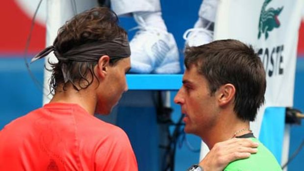 Spain's Rafael Nadal offers some conciliatory words to Brazil's Marcos Daniel after he retired hurt in their first-round match at Melbourne Park.