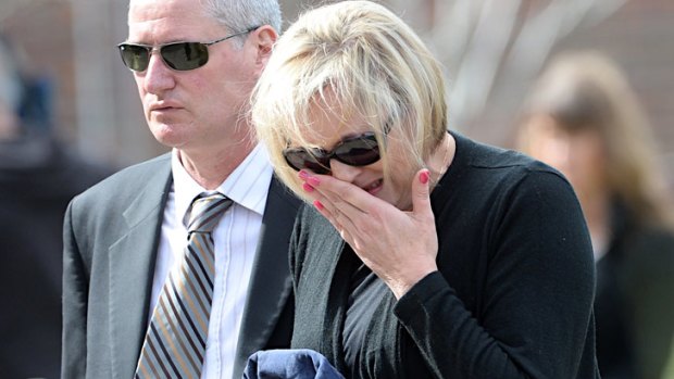 Chris Lane's mother Donna weeps as she arrives for the service.