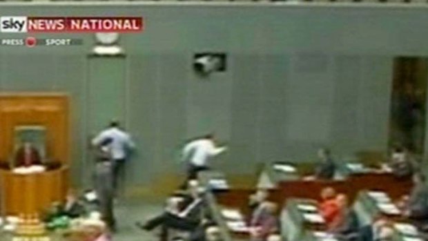 Television cameras show Opposition Leader Tony Abbott running for the exit at Parliament House yesterday.